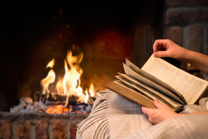 Reading book by a cozy fire.