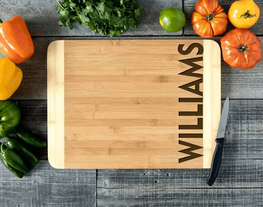 A green apple on top of a wooden cutting board, with Bamboo Cutting Boards and Kitchen