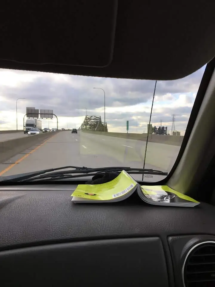 A close up of a car window with a map on the dashboard.