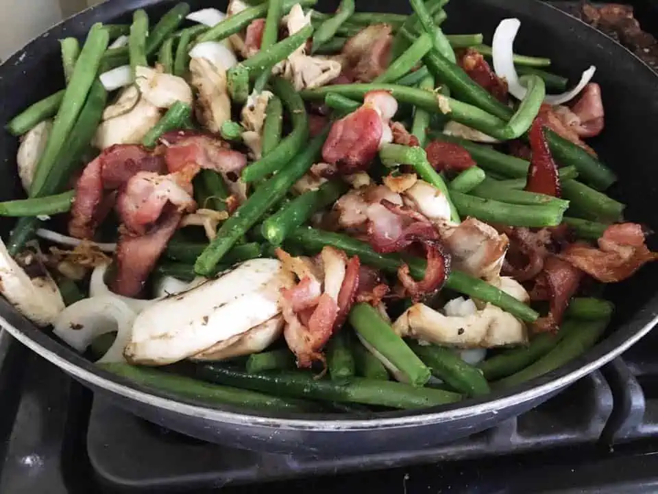 A pan filled with meat and vegetables, with Green bean