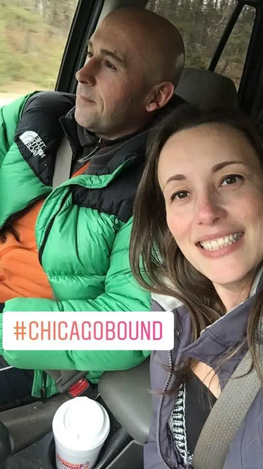 A couple of people posing for the camera heading to Chicago.
