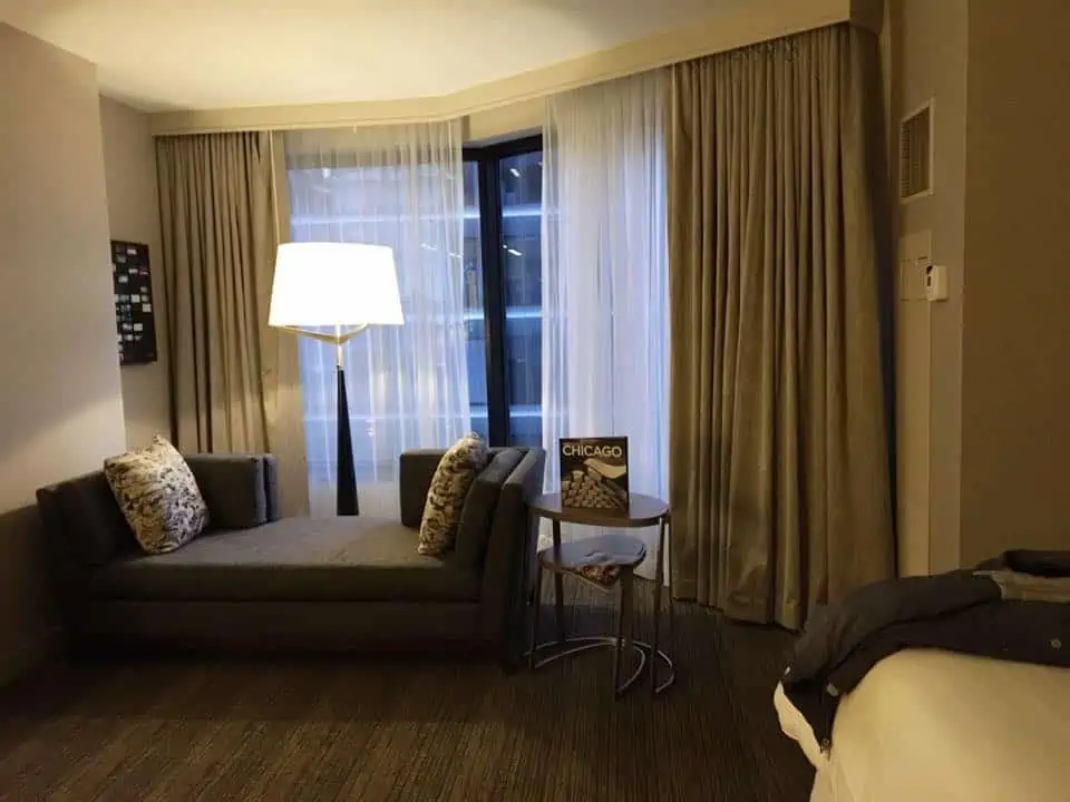 A hotel room in Chicago with a bed and looking at the camera