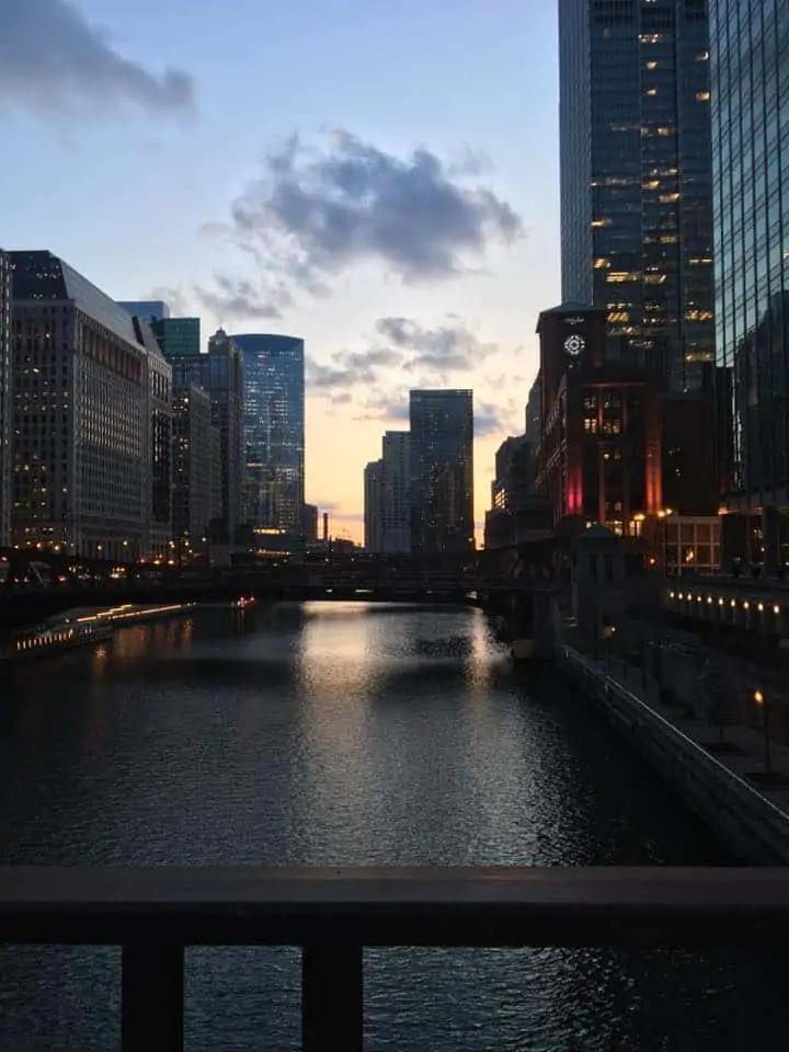 A bridge over a body of water with a city in the background