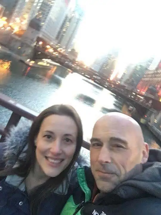 A group of people posing for the camera in front of the bridge in Chicago. 