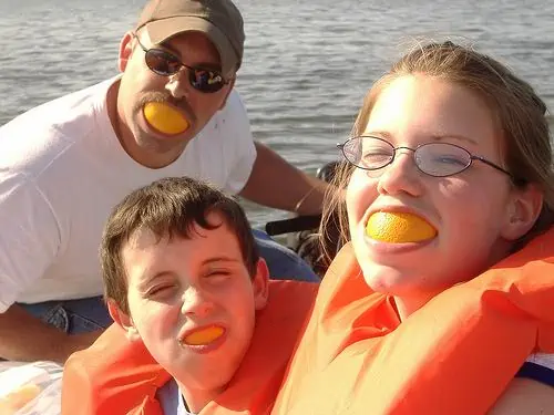 Orange slices in mouth of family members.