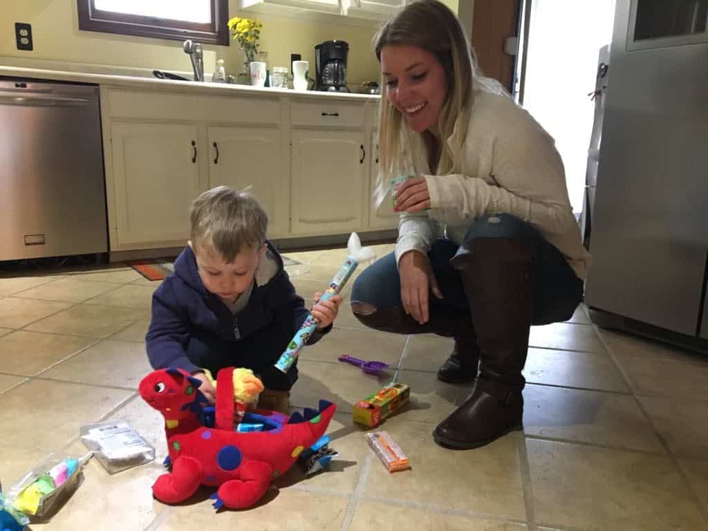 A mom and son playing on the kitchen floor after the little boy found his Easter basket from the Easter bunny.