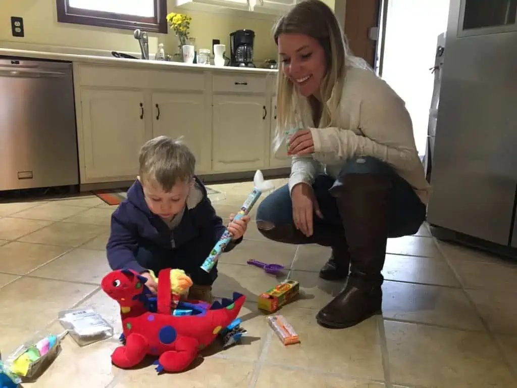 A mom and son playing on the kitchen floor after the little boy found his Easter basket from the Easter bunny.