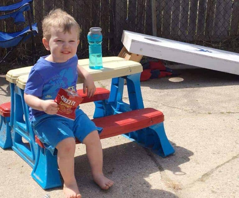A little boy sitting on a bench