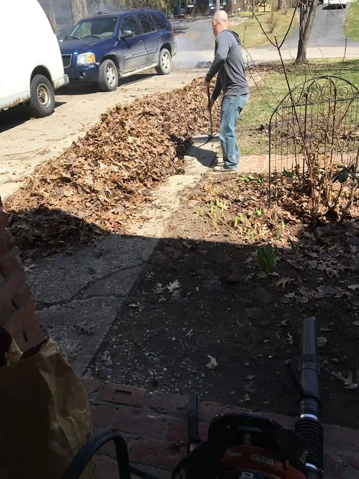 A man standing next to a car on a dirt road