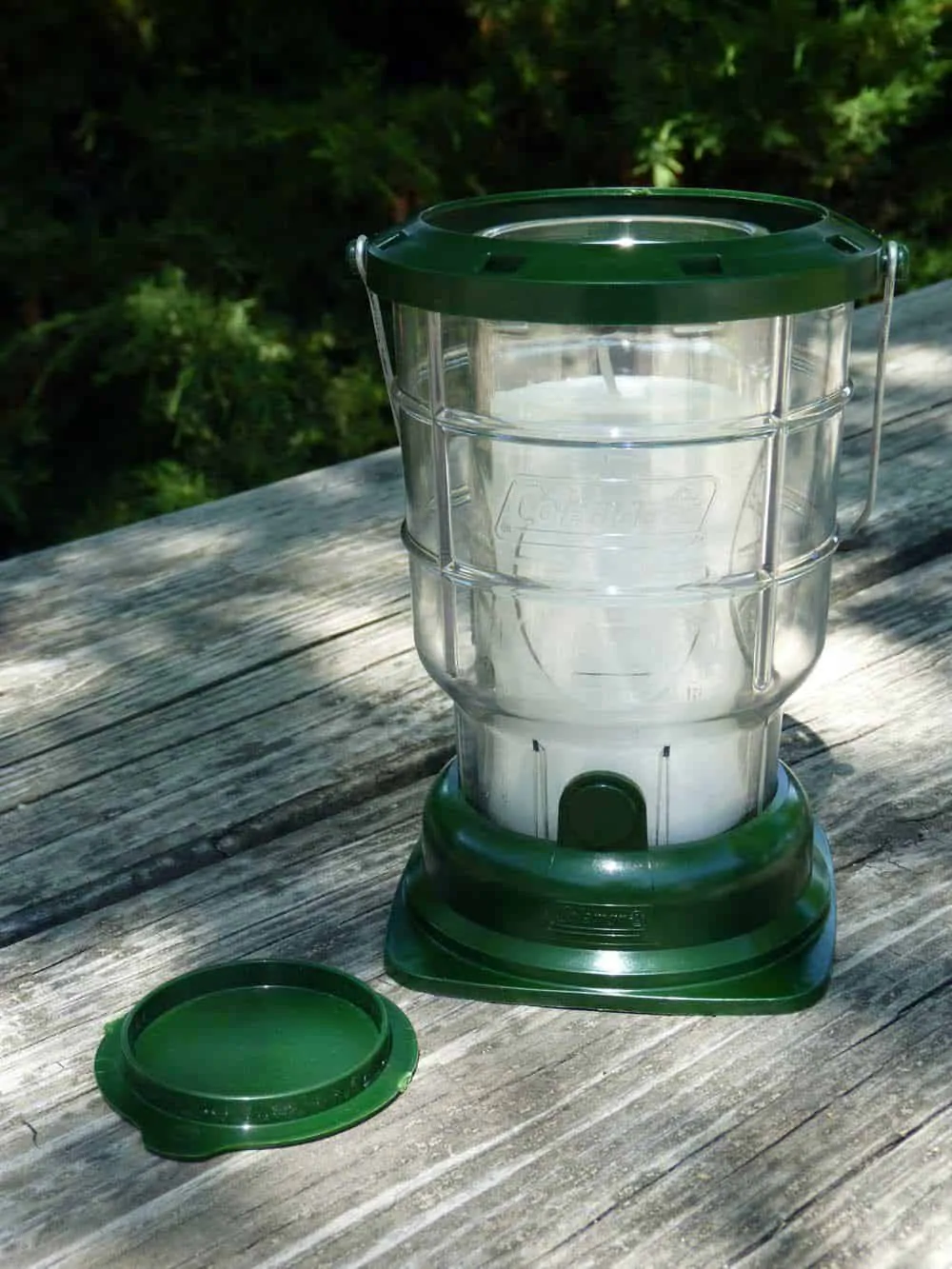 Coleman lantern sitting on a wooden picnic table