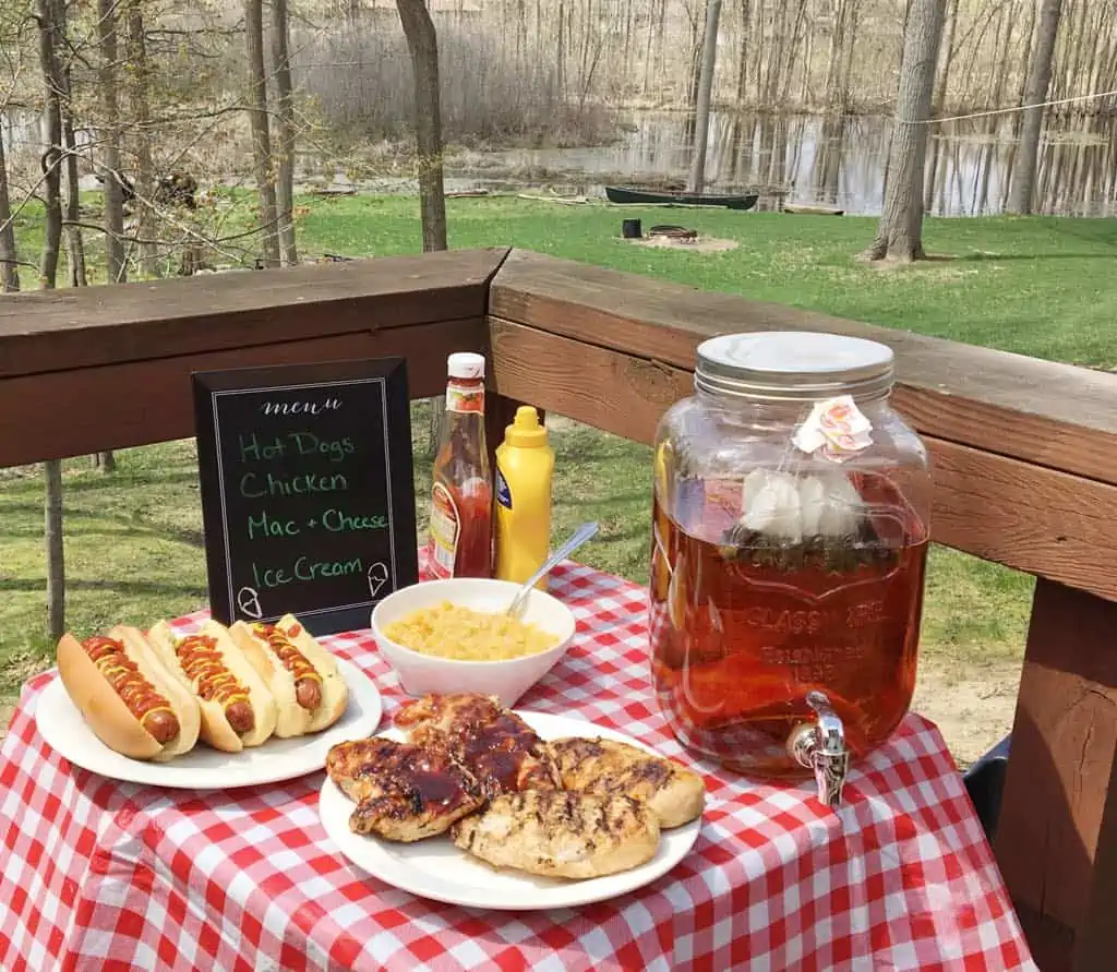 An outdoor picnic with chili dogs, sweet tea, and more delicious foods.