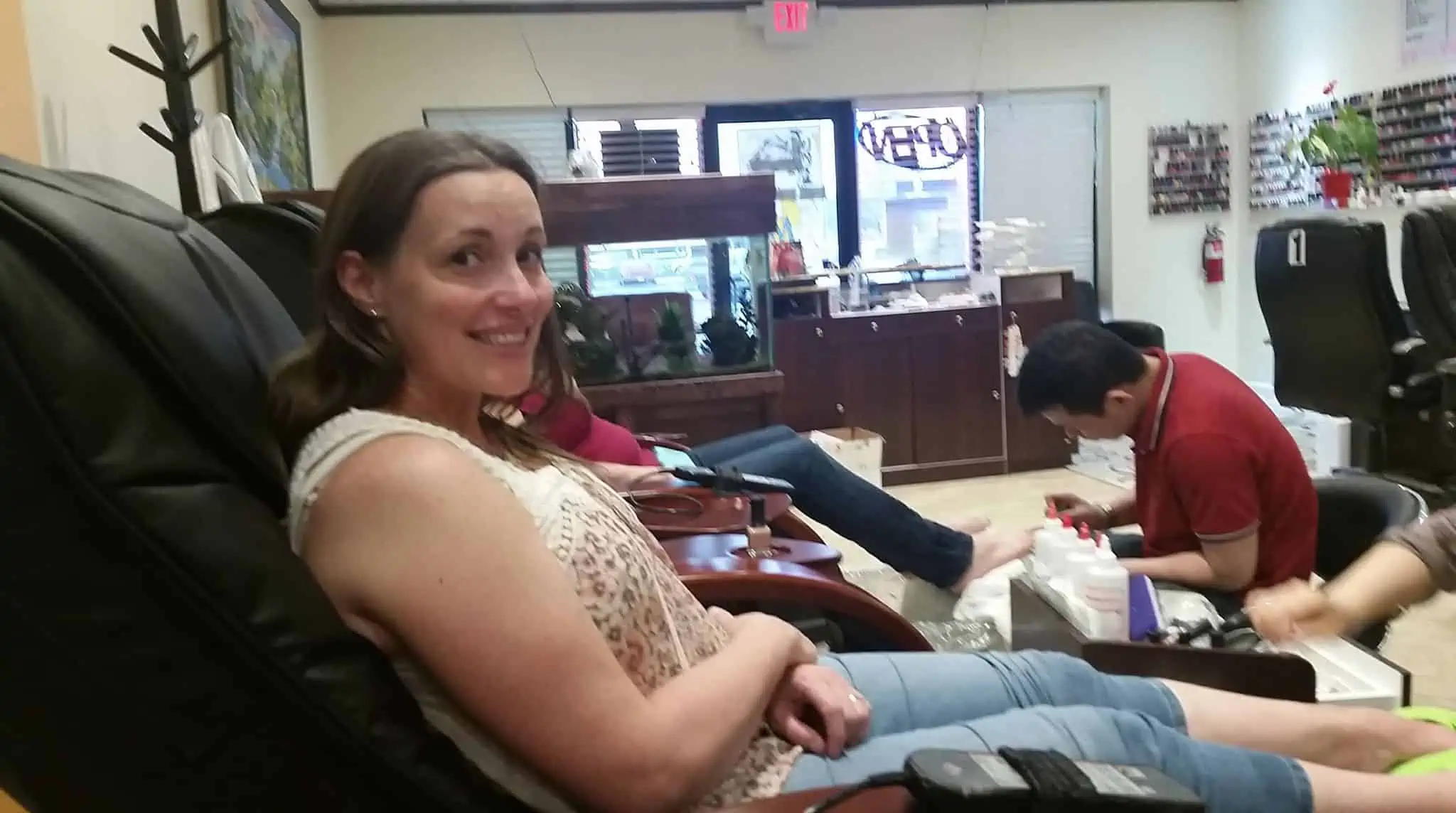 A person sitting and getting a pedicure. 