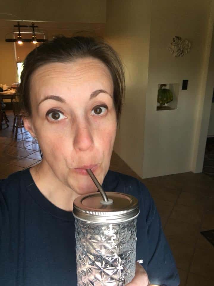 Woman drinking from a mason jar.