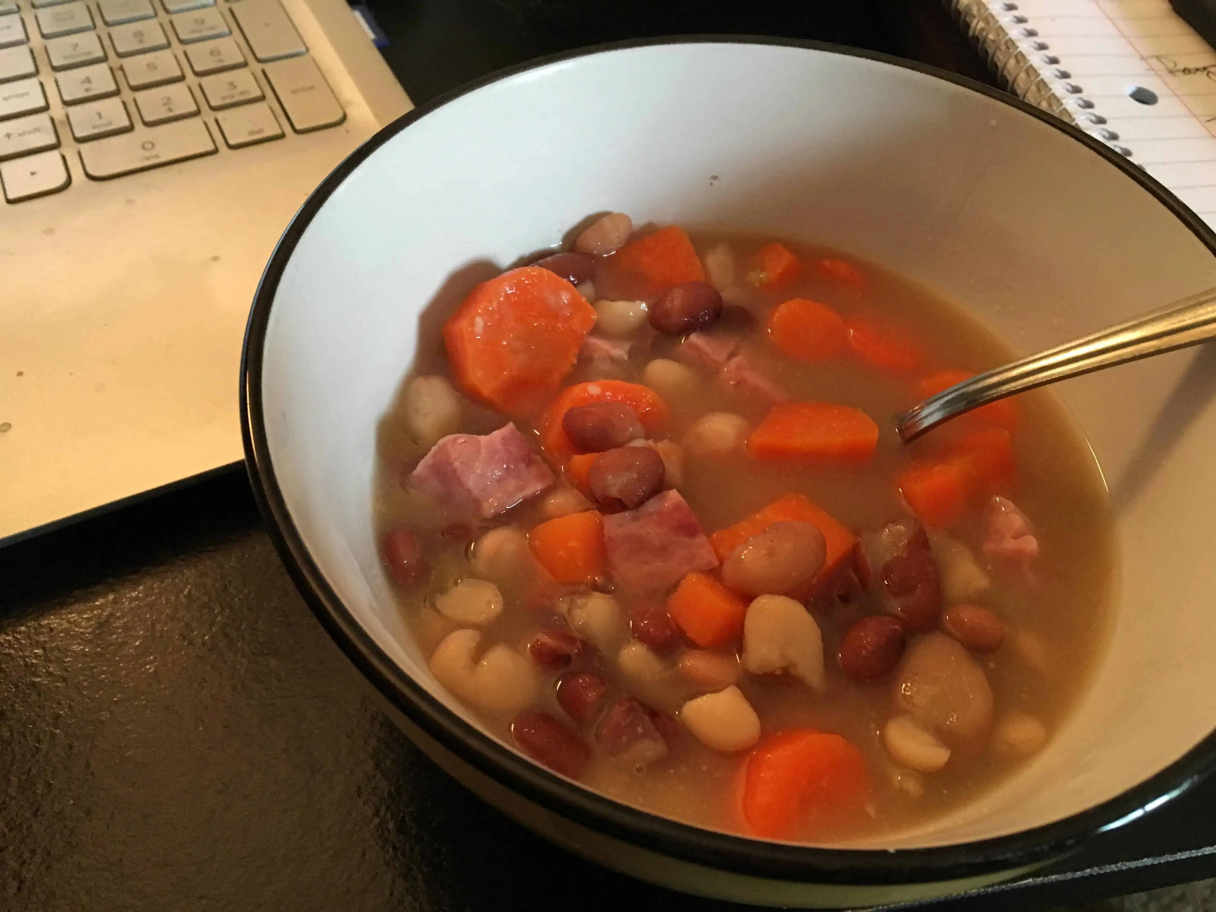 A bowl of soup and a spoon, with Bean and Recipes