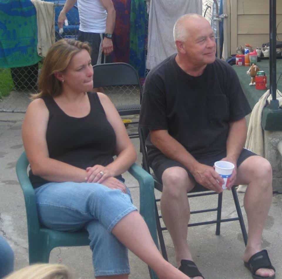 Man and woman sitting next to each other, smiling.
