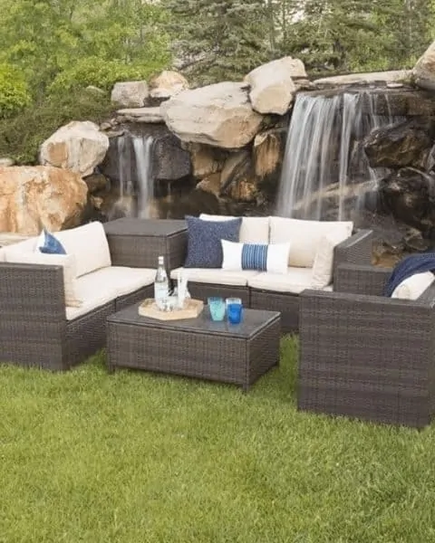 seven pieces of outdoor furniture sitting near a waterfall scene