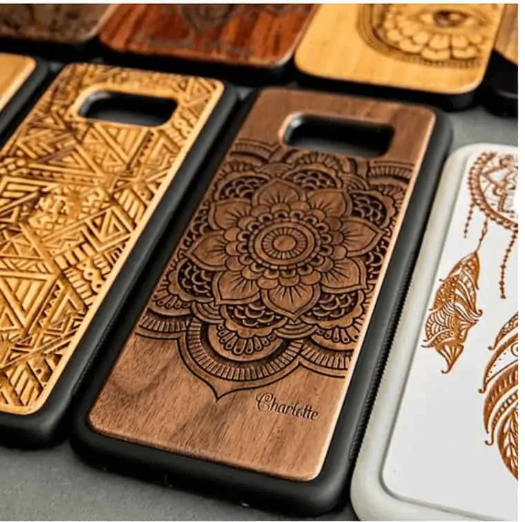 several wooden phone cases that are engraves with designs