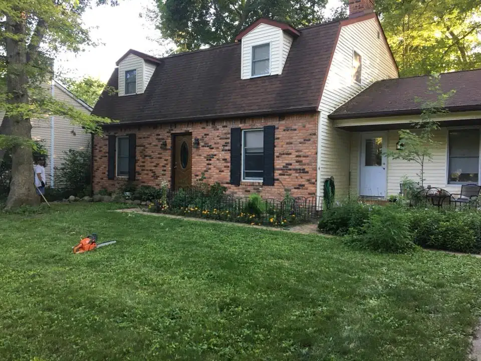 A large brick building with grass in front of a house