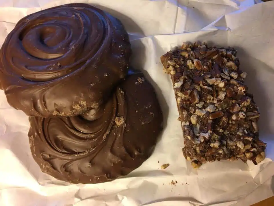 A piece of cake covered in chocolate sitting on top of a table. The Bavarian Inn Summertime Edition