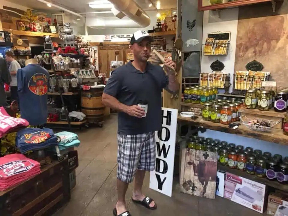 A person preparing food while standing in front of a store. The Bavarian Inn Summertime Edition