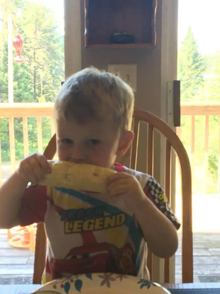 A little boy sitting at a table eating food