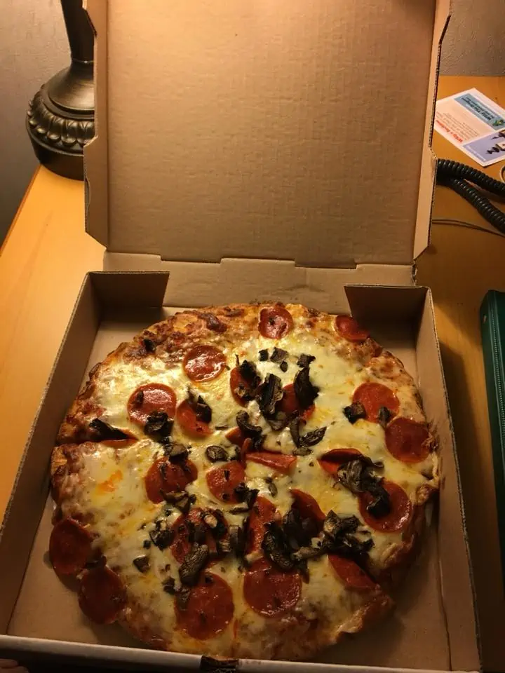 A pizza sitting on top of a box. The Bavarian Inn Summertime Edition