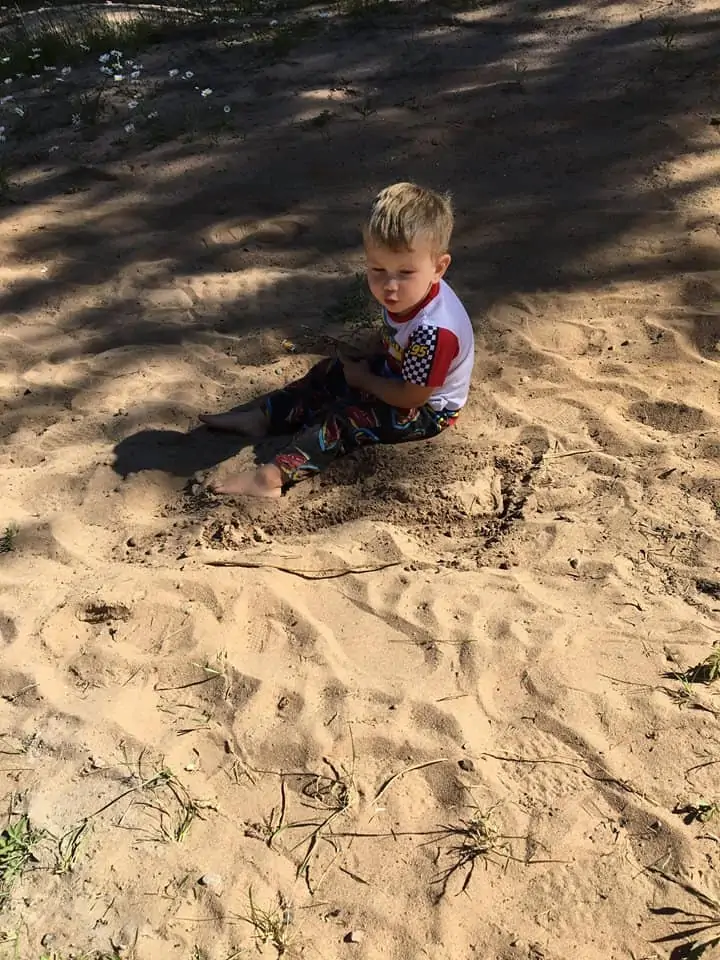 A little boy that is sitting in the sand
