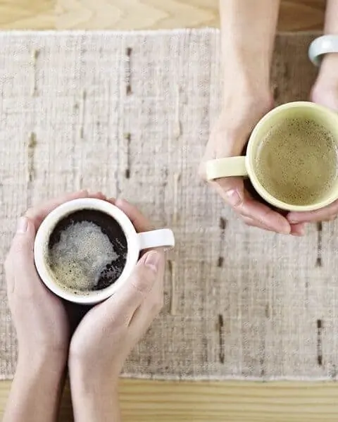 two people talking while drinking coffee.