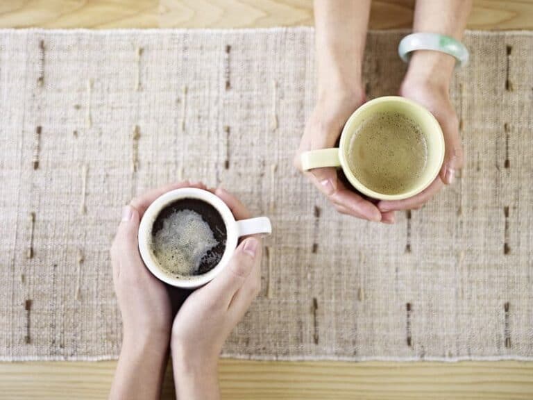 two people talking while drinking coffee.