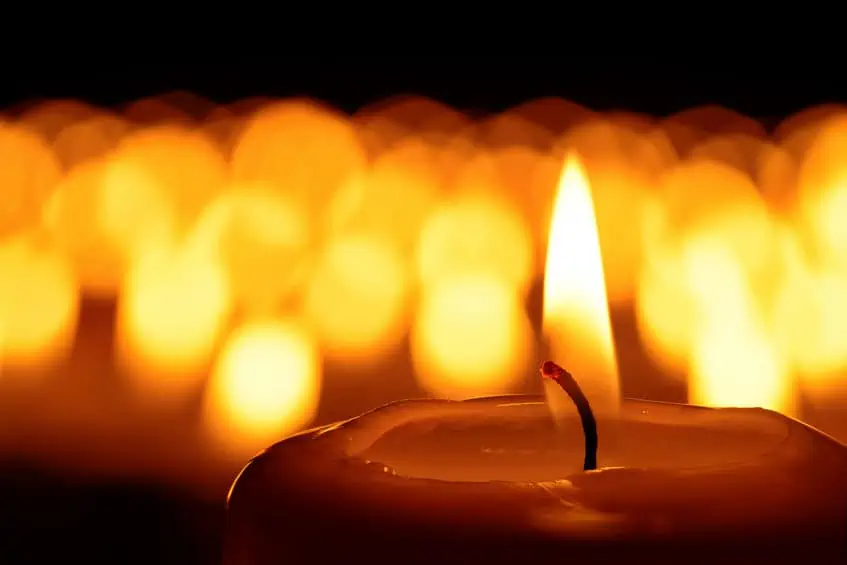 Candle burning against a dark background.