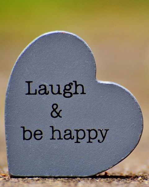 a heart shaped wooden plaque that says Laugh & Be Happy