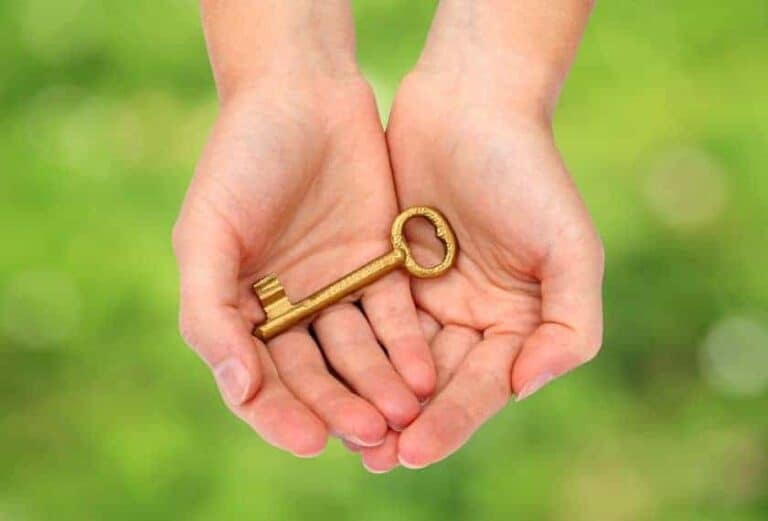 A woman holding a gold key in her palms.