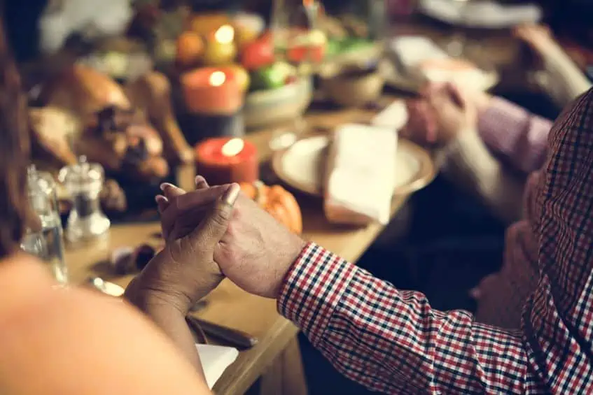 Thanksgiving family holding hands in prayer.