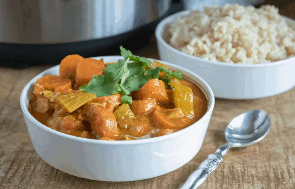 A bowl of food on a table, with Chicken and Curry