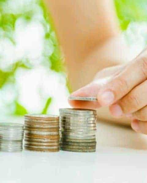 a woman stacking pennies, dimes, nickles and quarters