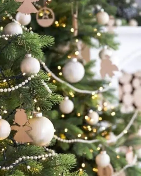 White Christmas ornaments on a Christmas tree.