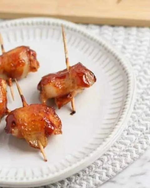 A plate of food with a fork and knife with Bacon Wrapped Chicken Bites