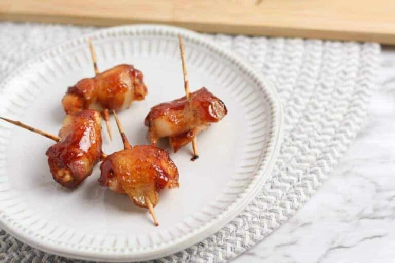 A plate of food with a fork and knife with Bacon Wrapped Chicken Bites