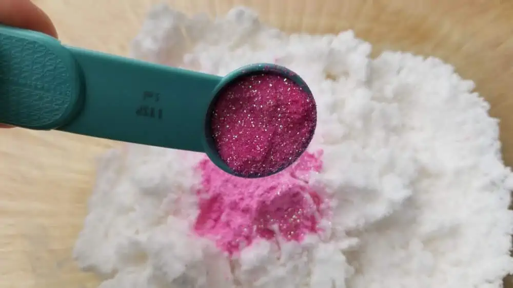 Adding glitter to bath bomb.