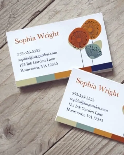 two business cards sitting on a wooden table