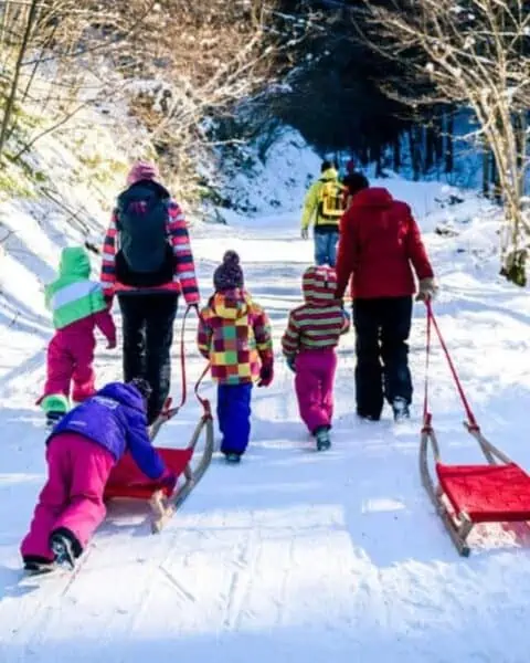 A family walking together to go winter sledding