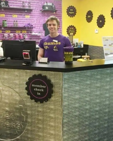 A man standing at the Member Check-In for planet fitness black card membership