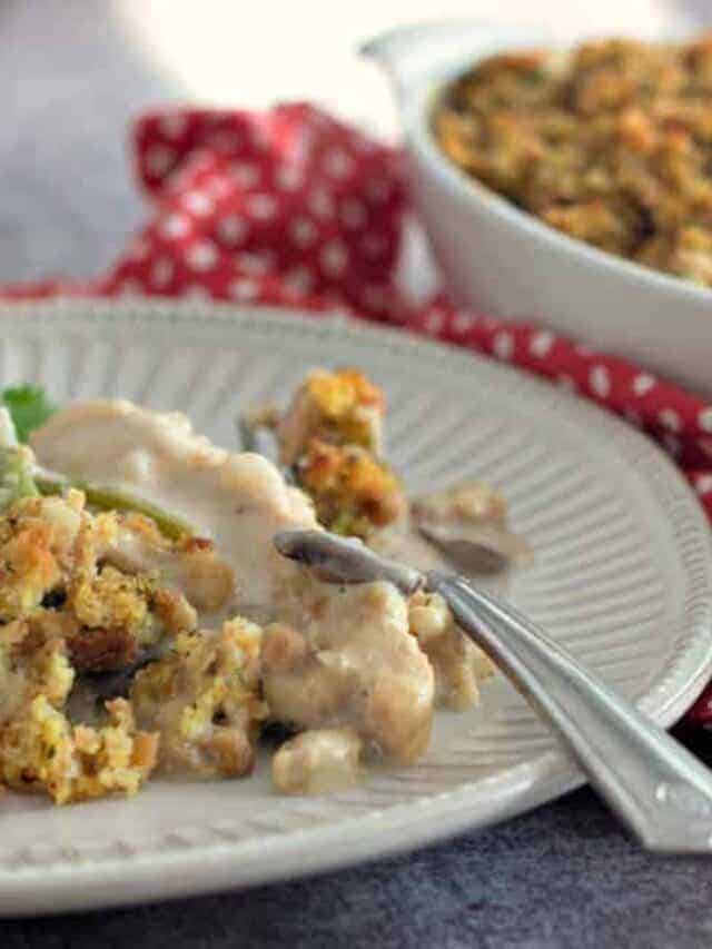 White plate of chicken stuffing casserole with gravy.