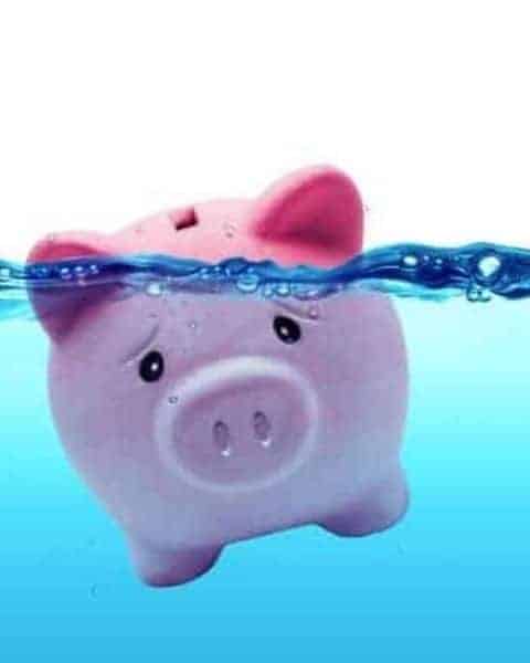 a pink piggy bank drowning in water