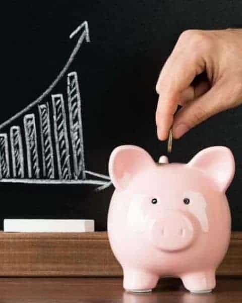 a person adding change to a piggy bank