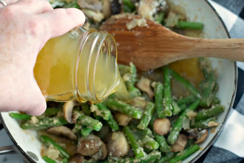 Stir chicken broth in mixed vegetables for chicken casserole. 
