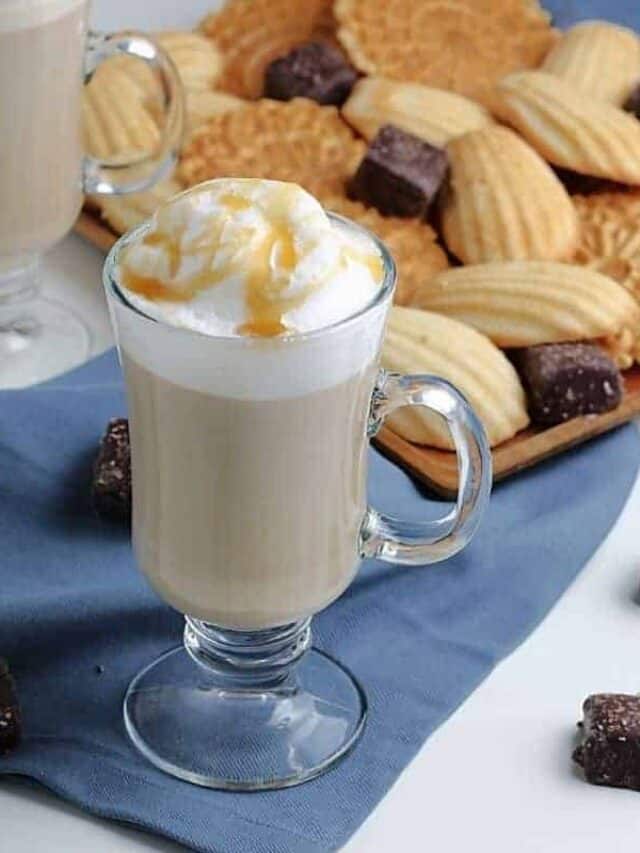 Vanilla latte drink in front of a plate of cookies.
