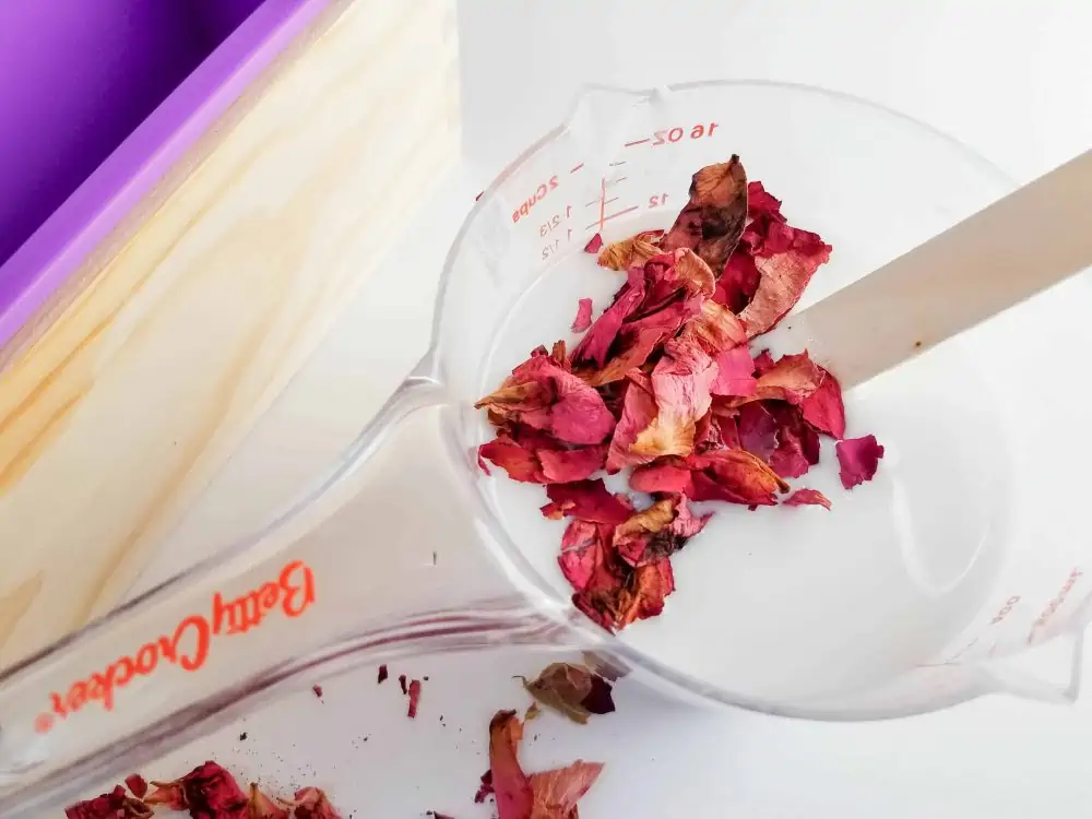 Add dried flower petals into the Botanical Goat Milk Handmade Soap mixture.