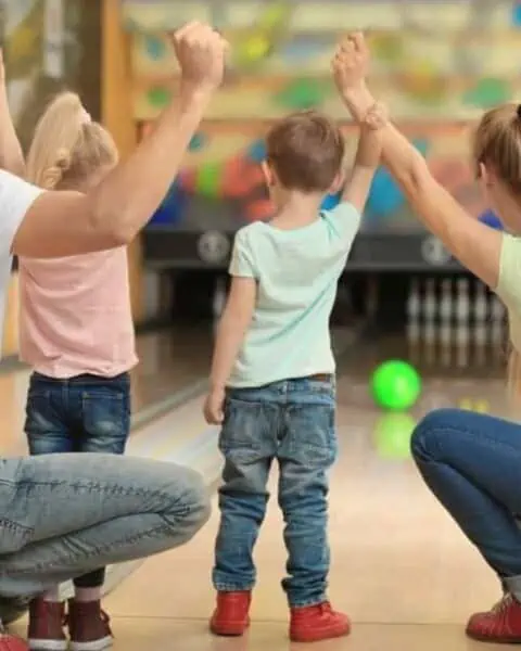 A family bowls together and celebrates the small children's game.