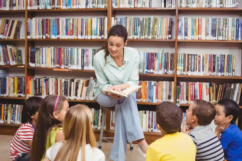 Librarian reading books for children\'s story time program.